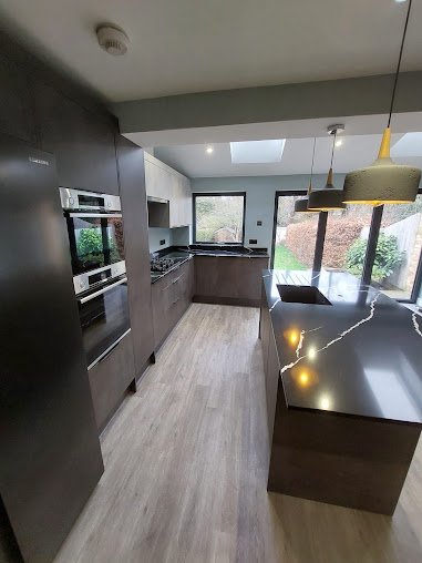 Modern kitchen renovation with marble worktop and integrated appliances by JCL Renovations